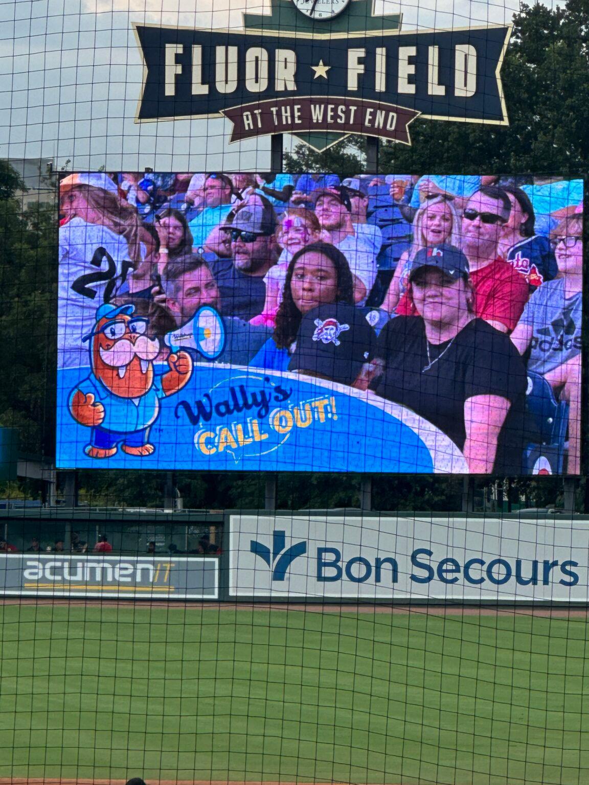 The stadium scoreboard at Fluor Field proudly displays the "Wally's Call Out" graphic with baseball fans seated, creating a memorable moment for all attendees.