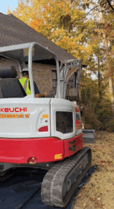Guy on back hoe machine about to dig in a yard. 
