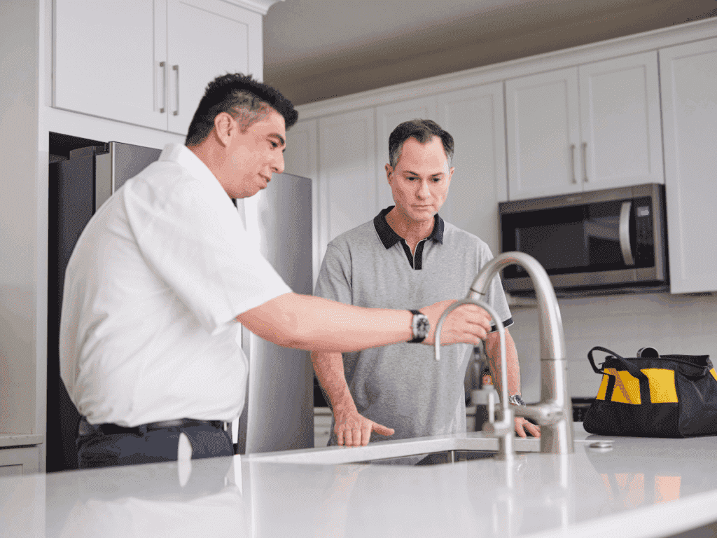 Tech at kitchen sink with customer