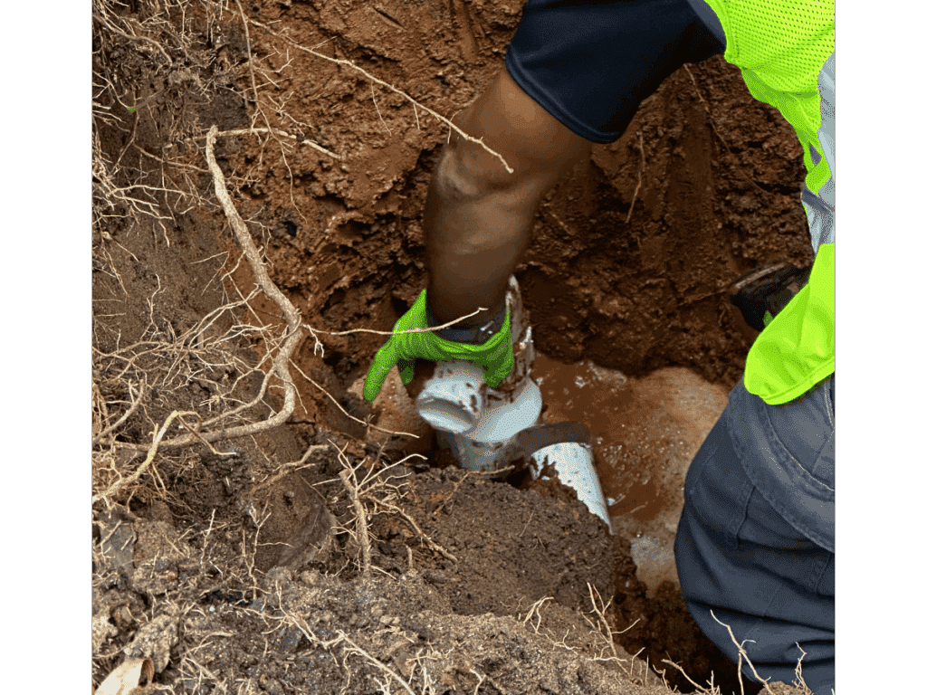 plumber in trench with main line