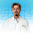 Portrait of a young man in a white work shirt with a Waldrop Plumbing Heating Air patch, against a blue dotted gradient background.