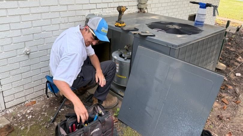 Waldrop tech conducting AC maintenance.