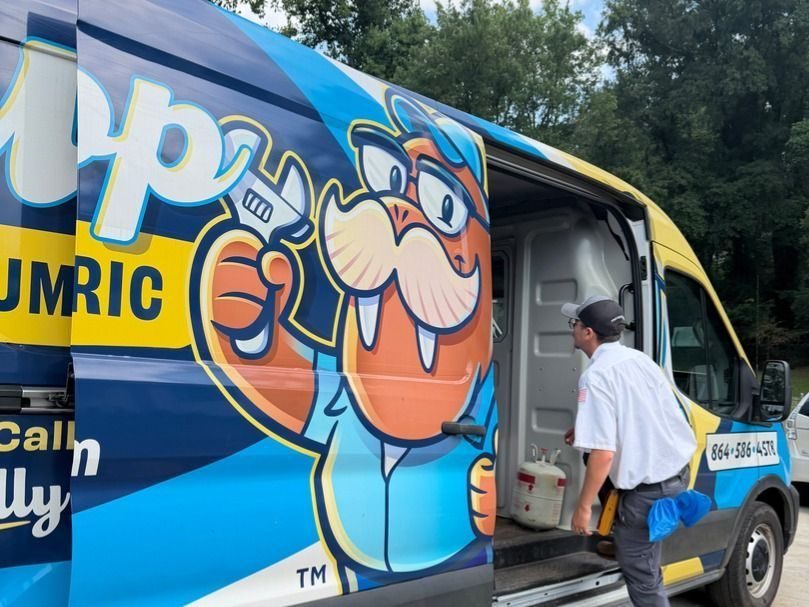 Colorful service van with a cartoon alligator mascot; a technician in uniform stands by the open side door.